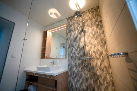 Moderne Dusche in einem stilvollen Badezimmer mit geometrischen Fliesen.